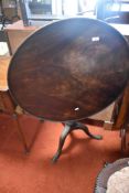 A Victorian mahogany flip top table having edged circular top on cage mechanism , turned column