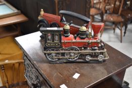 A pair of cast and painted metal fireside ornaments formed as a vintage car and steam train