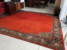 A large traditional wool carpet square having orange ground with patterned border, approx 394 x