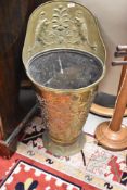 A large late 19th /early 20th century embossed brass coal scuttle, decorated in relief with Heraldic