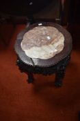 An Oriental style hardwood occasional table having marble inset, with elaborate frieze and ball