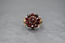 A 9ct gold Bohemian garnet cluster ring, the floral motif cluster having a closed back setting, with