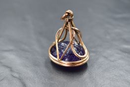 A large yellow metal fob pendant containing a large double sided carved amethyst stone, no marks,