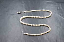A string of cultured pearls of graduated form having a diamante set silver clasp, approx 17' long