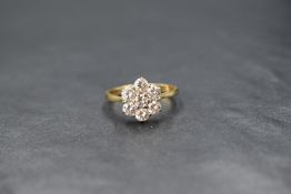 An 18ct gold daisy cluster ring having seven brilliant cut diamonds totalling approx 1ct in a claw