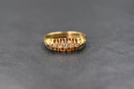 An 18ct gold five stone diamond set ring, the graduated diamond chips in an open gallery with