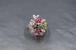 A 9ct gold multi cluster mixed gemstone ring in an open setting within a surround of diamond chip