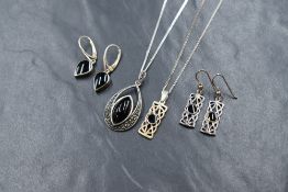 A suite of silver and jet jewellery, comprising a necklace and drop earrings, the central bezel