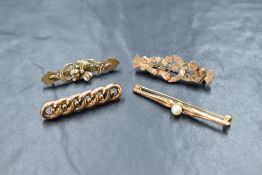 A group of four 9ct gold bar brooches, comprising two floral motif brooches, a curb link chain motif