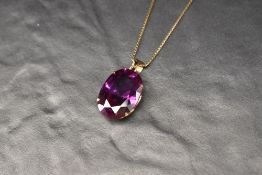 A 14ct gold purple gemstone possibly synthetic alexandrite set pendant, marked 14K, the oval cut