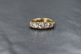 A yellow metal five stone diamond ring stamped 18ct, the five graduated old cut diamonds