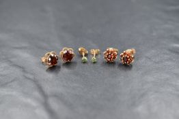 A pair of 9ct gold garnet set cluster stud earrings, the round cut garnets in eight garnet