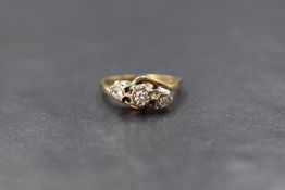 A 9ct gold diamond trilogy ring having three small diamonds in illusionary settings within crossover