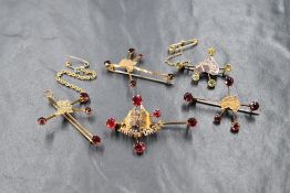 A group of five 9ct gold garnet, peridot and paste set Southern Cross constellation brooches, two