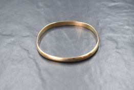 A 9ct gold Kathryn King gold bangle, the solid bangle of plain rounded form, marked 375,