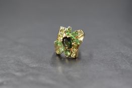 A 9ct gold and multi shade green gem stone ring by QVC, having off set shoulders and a 9ct gold