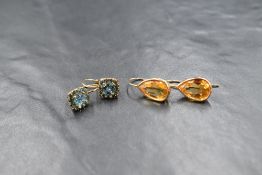 Two pairs of yellow metal loop drop earrings, one being 9ct gold with blue topaz cushion clusters