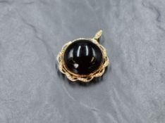A large yellow metal Garnet and seed pearl pendant/locket stamped 15C, the large garnet cabochon