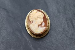 A 9ct gold conch shell cameo brooch depicting a maiden in profile within a plain 9ct gold mount with