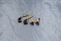 A pair of 9ct gold smoky quartz drop earrings, the kite cut smoky quartz in a four claw settings,