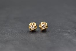 A pair of yellow metal diamond stud earrings, each diamond approx 0.25ct in a frilled claw set mount