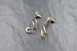 A pair of yellow metal cubic zirconia stud earrings stamped 14K having open swirl drop