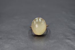A 15ct gold cabochon possibly chrysoberyl set ring, the pale yellow-green cabochon displaying