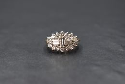 An 18ct gold diamond cluster ring having a vertical set baguette cut diamond between two further