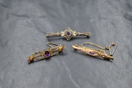 A 9ct gold amethyst and seed pearl set bar brooch, the central round cut amethyst in an openwork