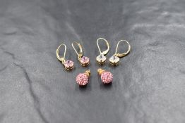 Two pairs of yellow metal loop drop earrings stamped 585 having pink and white gem stone drops,