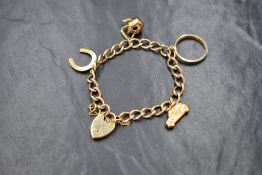 A 9ct gold curb link charm bracelet, having a 9ct gold horseshoe, 9ct gold car, 9ct gold kettle