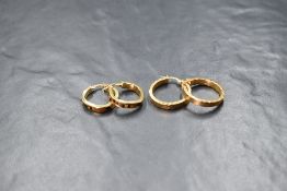 A pair of 9ct gold hoop earrings, in a flattened rope motif, marked 375, along with a further pair