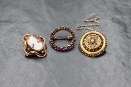 A 14ct gold garnet set circular brooch, the open circular brooch having rose cut garnets, marked