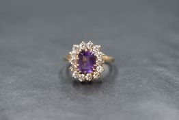 A 9ct gold amethyst and cubic zirconia cluster ring, having a baguette cut amethyst within a