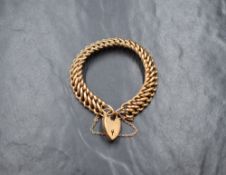 A Victorian rose gold double link bracelet stamped 9ct having a monogrammed padlock clasp and safety