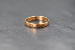 An 18ct gold band, of plain form having worn engraved decoration, marked 18 with hallmarks, ring