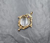 An Edwardian yellow metal glass locket pendant stamped 9ct having a central locket within a