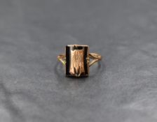 A rose gold signet ring stamped 9ct having a black panel bearing an applique letter M to split
