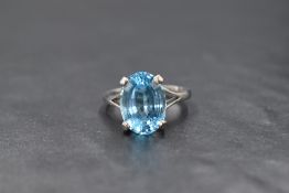 An 18ct white gold blue topaz ring having a large oval cut stone, 14mm x 10mm, in a four claw raised