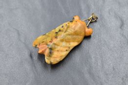 A carved bumble bee jasper pendant in the form of a flying insect having a yellow metal loop,