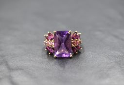 A 9ct gold amethyst ring by QVC, having a large emerald cut amethyst flanked by marquise and