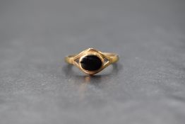 A 9ct gold onyx set signet ring, the oval bezel set onyx panel in a pierced setting, marked 375,