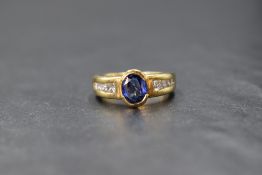 A 18ct gold Ceylon sapphire and diamond ring having a central oval sapphire of approx 0.6ct in a