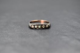 A white and yellow metal ring stamped 9ct & silver having five paste stones in an oval gallery
