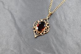 A 9ct gold garnet set pendant, the large oval cur garnet measuring approximately 14mm x 10mm x