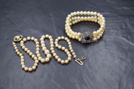 A 20' string of graduated cultured pearls with yellow metal box clasp and safety chain, no marks,