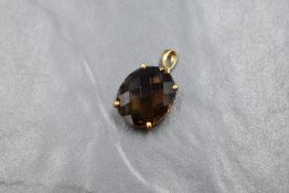 A large QVC 9ct gold smoky quartz pendant, the oval mixed cut smoky quartz measuring approximately
