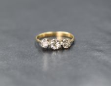 A yellow metal three stone diamond ring stamped 18C, the three old cut diamonds, approx 1ct total in