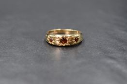 A 9ct gold garnet set gypsy ring, the three graduated round cut garnets in star settings, marked