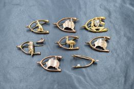 A group of eight gold and yellow metal presumed gold Australian motif wishbone brooches, having